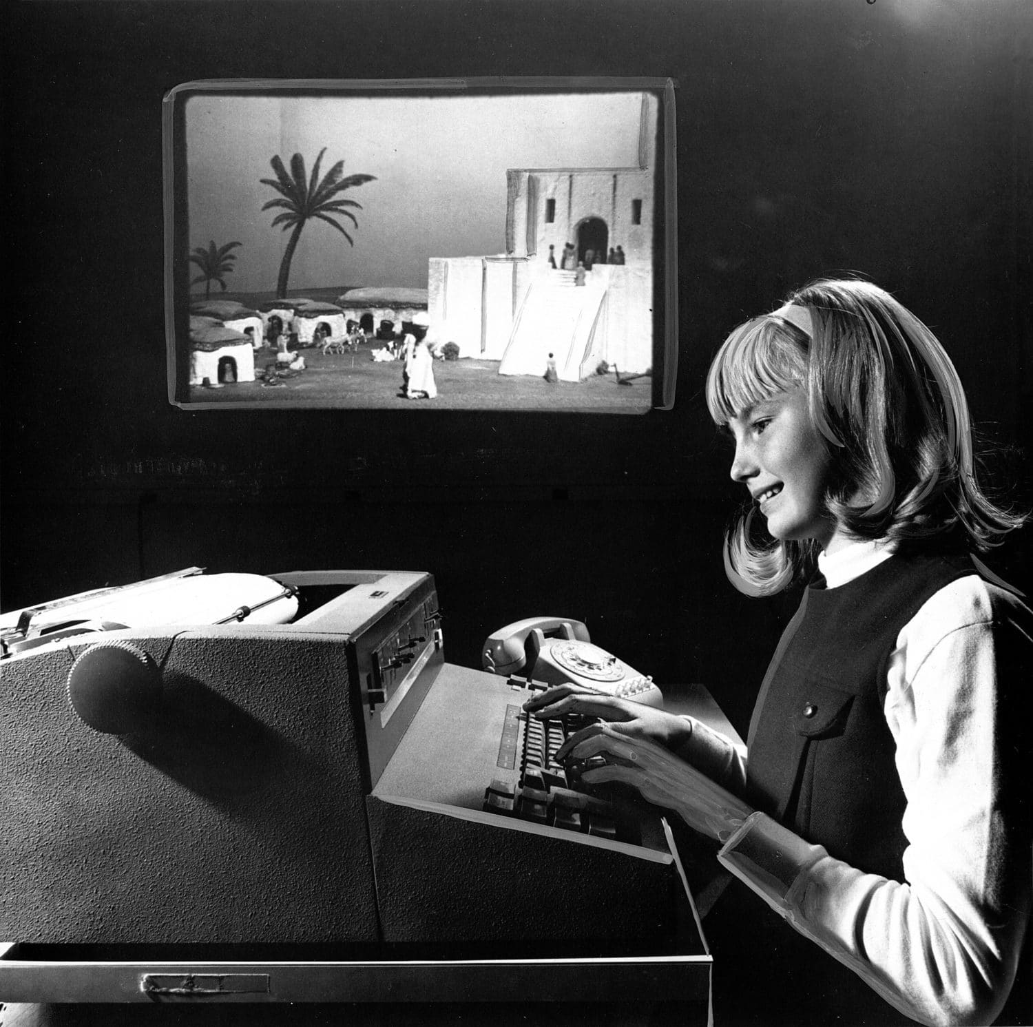 （这张1968年的照片显示一名女学生在玩苏美尔游戏。背景中的一张幻灯片说明了这一行动。(来源：维基百科))